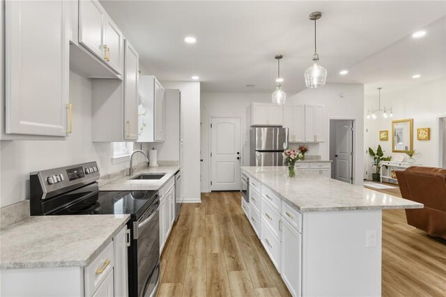 2641 Anchor Dr, Marrero, LA 70072 - kitchen with stainless steel appliances, a sink, white cabinets, light wood-type flooring, and a kitchen island