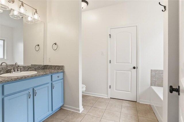 2641 Anchor Dr, Marrero, LA 70072 - bathroom with vanity, tile patterned flooring, toilet, a garden tub, and baseboards