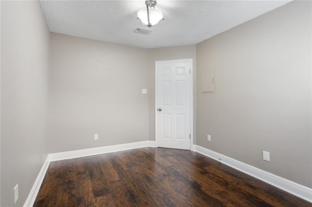 139 Avant Garde Cir Unit 139, Kenner, LA 70065 - spare room featuring dark wood finished floors, baseboards, and a textured ceiling