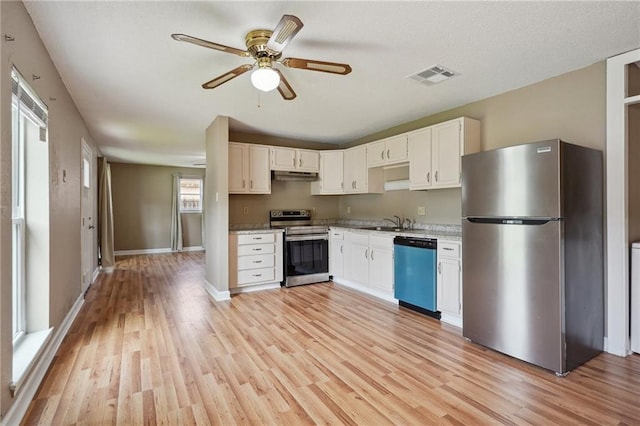 4124 Ames Blvd, Marrero, LA 70072 - kitchen featuring appliances with stainless steel finishes, under cabinet range hood, light wood finished floors, a ceiling fan, and white cabinetry