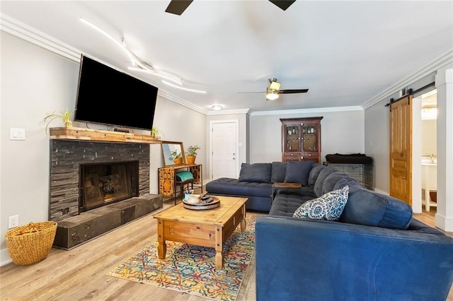 623 Bonnabel Blvd, Metairie, LA 70005 - living area featuring a ceiling fan, wood finished floors, a barn door, ornamental molding, and a fireplace