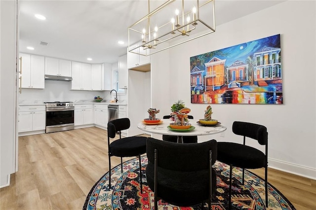 1617 Claudius St, Metairie, LA 70005 - dining area with light wood-type flooring, recessed lighting, baseboards, and a chandelier