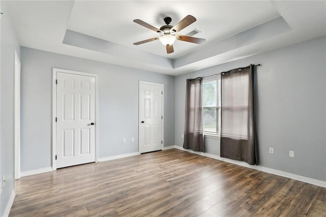 185 Lark St, Slidell, LA 70460 - unfurnished bedroom with a tray ceiling, wood finished floors, and baseboards