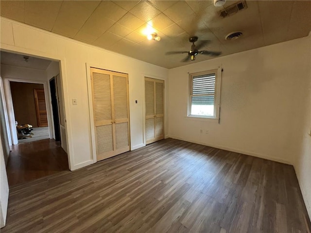 1638 Stafford St, Gretna, LA 70053 - unfurnished bedroom featuring two closets, dark wood-style flooring, and baseboards