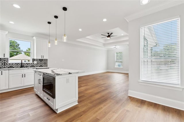 2901 Sam Lenox St, Jefferson, LA 70121 - kitchen featuring crown molding, ceiling fan, built in microwave, white cabinets, and decorative backsplash