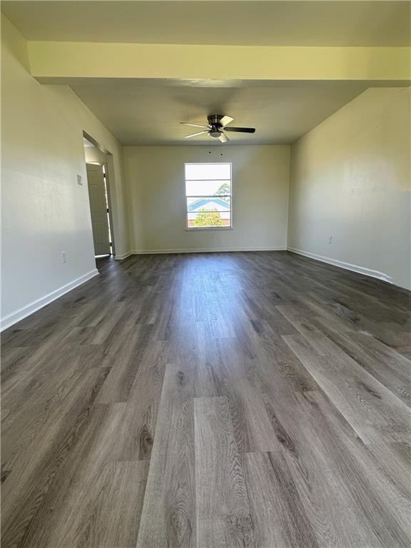 733 Morningside Dr, Gretna, LA 70056 - empty room with dark wood-style floors, ceiling fan, and baseboards
