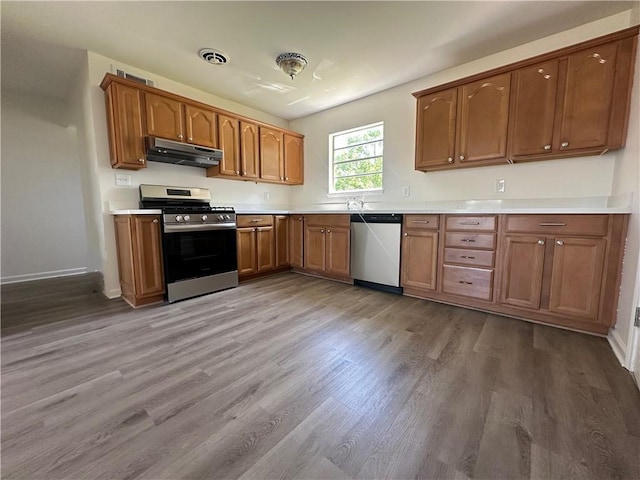 733 Morningside Dr, Gretna, LA 70056 - kitchen featuring stainless steel appliances, under cabinet range hood, wood finished floors, and brown cabinetry