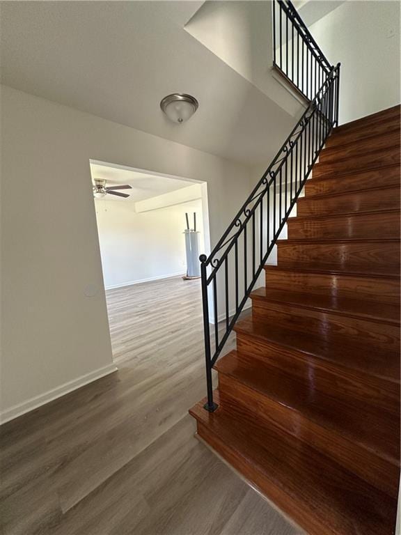 733 Morningside Dr, Gretna, LA 70056 - stairway featuring wood finished floors, baseboards, water heater, and ceiling fan