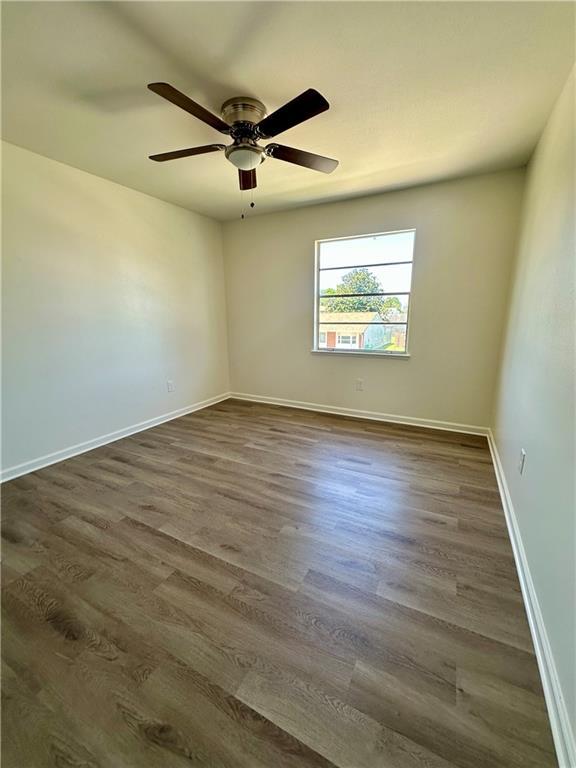 733 Morningside Dr, Gretna, LA 70056 - empty room with dark wood finished floors, baseboards, and a ceiling fan