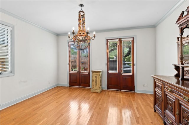 2627 S Carrollton Ave, New Orleans, LA 70118 - unfurnished dining area with light wood-style floors, a chandelier, baseboards, and crown molding