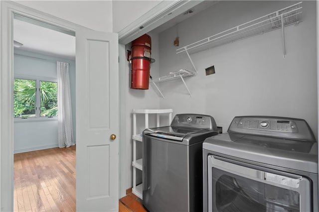 2627 S Carrollton Ave, New Orleans, LA 70118 - washroom with washer and clothes dryer, wood finished floors, and baseboards