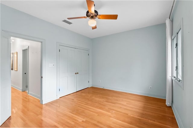 2627 S Carrollton Ave, New Orleans, LA 70118 - unfurnished bedroom featuring light wood-type flooring, baseboards, a closet, and a ceiling fan