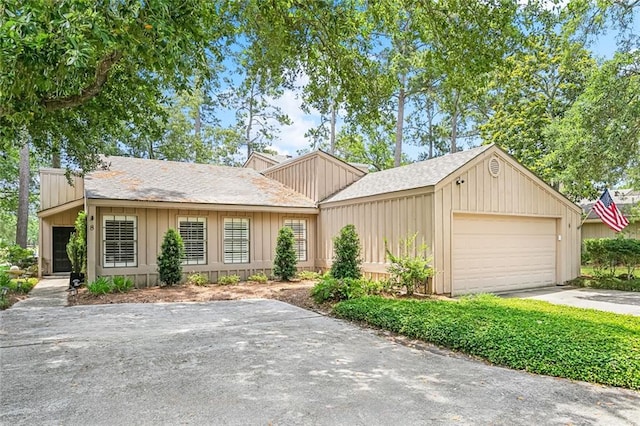 8 S Court Villa Unit 8, Mandeville, LA 70471 - view of front of house with driveway, a garage, board and batten siding, and a shingled roof