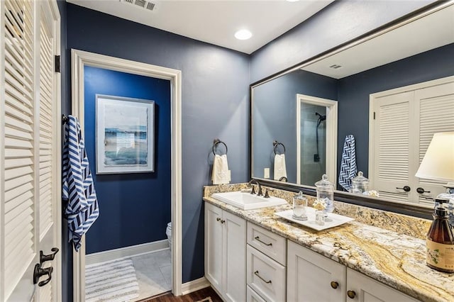8 S Court Villa Unit 8, Mandeville, LA 70471 - bathroom featuring toilet, double vanity, a shower, and baseboards