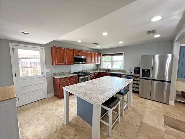 6021 Amhurst St, Metairie, LA 70003 - kitchen with stainless steel appliances, recessed lighting, baseboards, a sink, and brown cabinetry