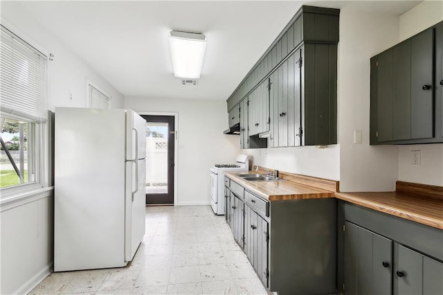 929 Franklin Ave, Jefferson, LA 70123 - kitchen with white appliances, a sink, baseboards, under cabinet range hood, and gray cabinetry