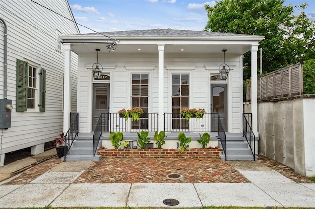 2417 Rousseau St, New Orleans, LA 70130 - view of exterior entry featuring a porch and a shingled roof