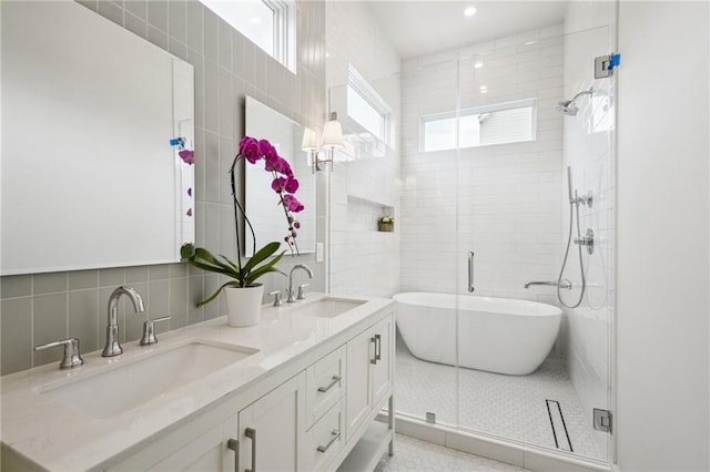 2417 Rousseau St, New Orleans, LA 70130 - full bath with tile walls, a soaking tub, double vanity, a shower stall, and decorative backsplash