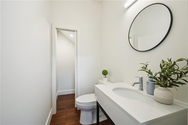 2417 Rousseau St, New Orleans, LA 70130 - half bathroom featuring toilet, vanity, wood finished floors, and baseboards