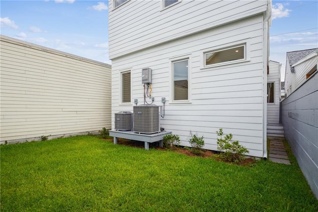 2417 Rousseau St, New Orleans, LA 70130 - back of house featuring central AC unit and a lawn