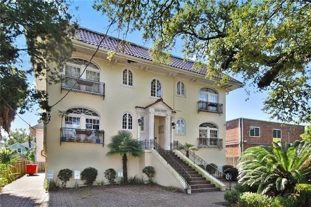 2615 S Carrollton Ave Unit D, New Orleans, LA 70118 - mediterranean / spanish-style home featuring stucco siding, a balcony, and a tile roof