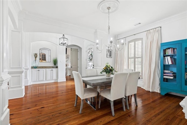 126 Tchefuncta Dr S, Covington, LA 70433 - dining space with dark wood finished floors, crown molding, a chandelier, and arched walkways