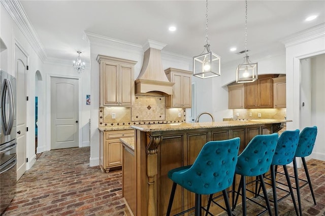 126 Tchefuncta Dr S, Covington, LA 70433 - kitchen with brick flooring, custom range hood, a breakfast bar, light stone counters, and recessed lighting