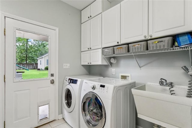 203 Willow Cir, Mandeville, LA 70471 - laundry area featuring cabinet space, washer and clothes dryer, and light tile patterned floors