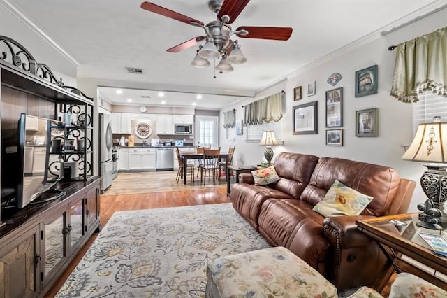 929 Carnation Ave, Metairie, LA 70001 - living room with ornamental molding, light wood-type flooring, a ceiling fan, and recessed lighting