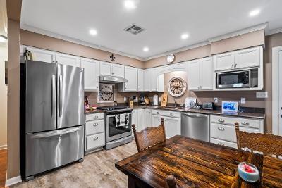 929 Carnation Ave, Metairie, LA 70001 - kitchen with appliances with stainless steel finishes, dark countertops, crown molding, under cabinet range hood, and white cabinetry
