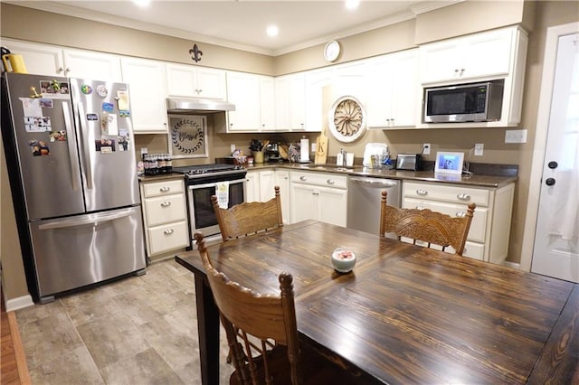 929 Carnation Ave, Metairie, LA 70001 - kitchen with appliances with stainless steel finishes, under cabinet range hood, dark countertops, a sink, and ornamental molding
