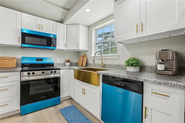 620 River Oaks Dr, New Orleans, LA 70131 - kitchen featuring appliances with stainless steel finishes, a sink, white cabinets, light wood-type flooring, and light stone countertops