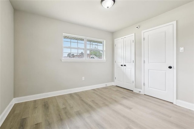 620 River Oaks Dr, New Orleans, LA 70131 - unfurnished bedroom with light wood-style flooring, baseboards, and a closet