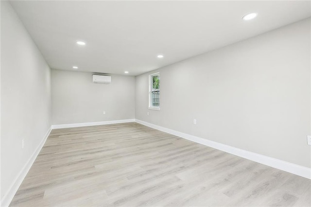 620 River Oaks Dr, New Orleans, LA 70131 - empty room featuring an AC wall unit, recessed lighting, light wood finished floors, and baseboards