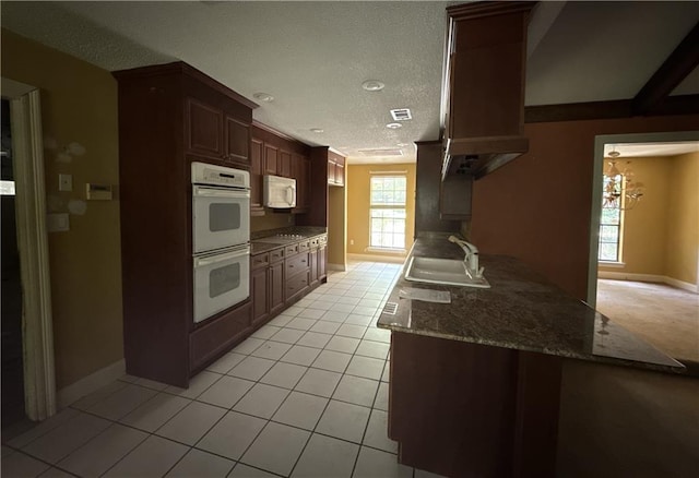 119 Devereux Dr, Slidell, LA 70461 - kitchen featuring a sink, white microwave, double wall oven, baseboards, and a textured ceiling