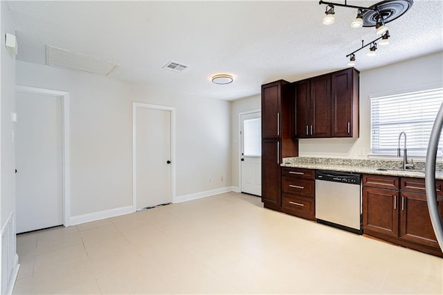 2924 Elizabeth St, Metairie, LA 70003 - kitchen with stainless steel dishwasher, a sink, dark brown cabinetry, light stone counters, and baseboards