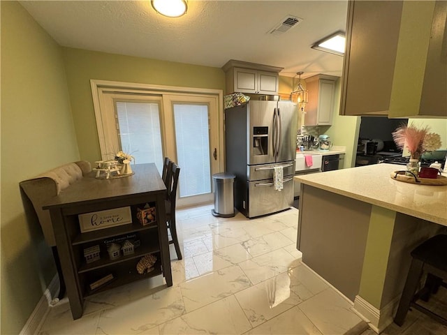 5121 Pike Dr, Metairie, LA 70003 - kitchen featuring stainless steel refrigerator with ice dispenser, light marble finish flooring, a kitchen bar, gray cabinetry, and pendant lighting