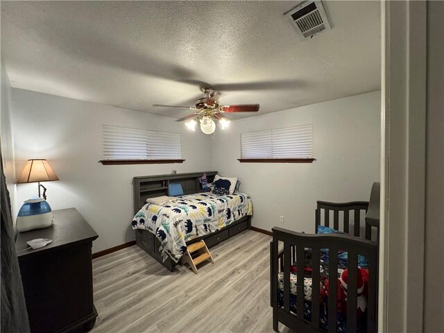 5121 Pike Dr, Metairie, LA 70003 - bedroom featuring light wood finished floors, a textured ceiling, and a ceiling fan