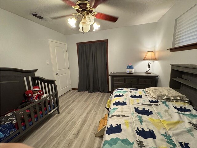 5121 Pike Dr, Metairie, LA 70003 - bedroom featuring light wood-style floors, a textured ceiling, and a ceiling fan