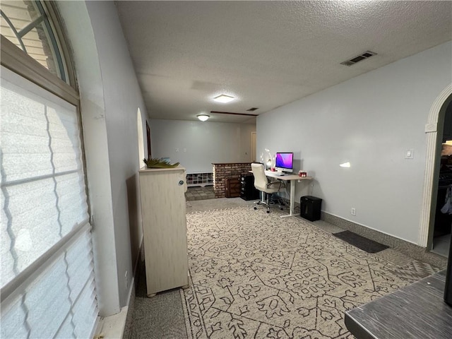 5121 Pike Dr, Metairie, LA 70003 - home office with a textured ceiling, healthy amount of natural light, arched walkways, and carpet