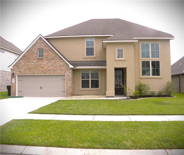40107 Reese Ln, Prairieville, LA 70769 - view of front of house with stucco siding, driveway, roof with shingles, a front lawn, and brick siding