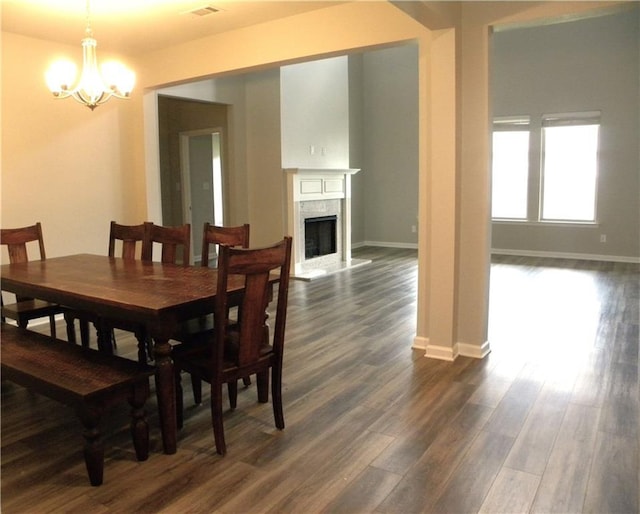 40107 Reese Ln, Prairieville, LA 70769 - dining space featuring a chandelier, dark wood-type flooring, baseboards, and a fireplace