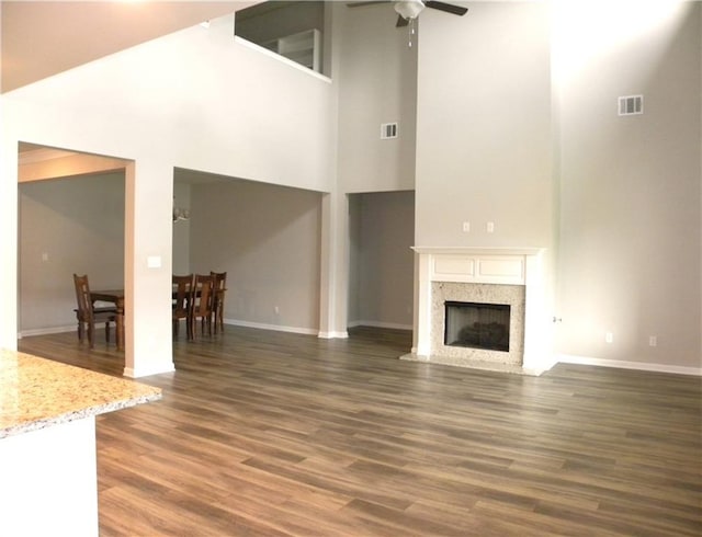 40107 Reese Ln, Prairieville, LA 70769 - unfurnished living room with a towering ceiling, ceiling fan, baseboards, and wood finished floors