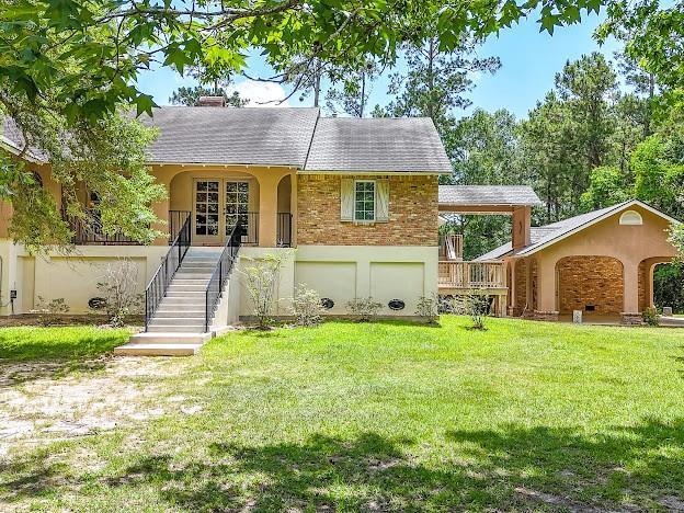 109 Kendrick Dr, Slidell, LA 70461 - single story home with stairway, a front lawn, french doors, stucco siding, and a shingled roof