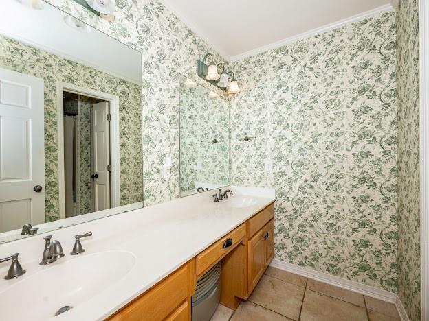 109 Kendrick Dr, Slidell, LA 70461 - bathroom with baseboards, double vanity, wallpapered walls, tile patterned flooring, and ornamental molding