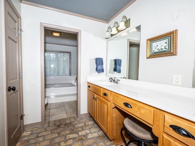 109 Kendrick Dr, Slidell, LA 70461 - full bathroom with vanity, a garden tub, ornamental molding, and toilet