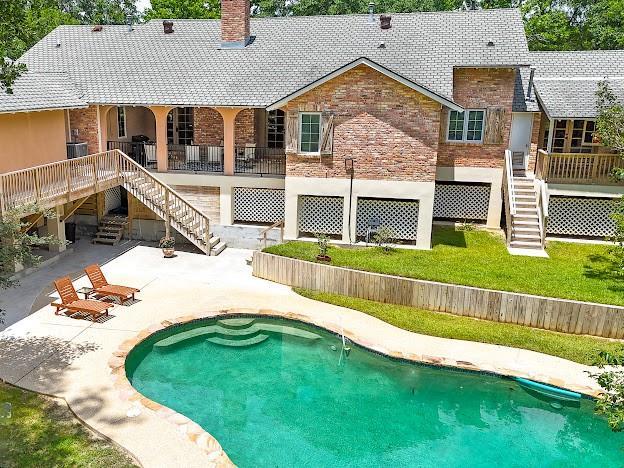 109 Kendrick Dr, Slidell, LA 70461 - back of house featuring stairway, a chimney, a patio, stone siding, and a wooden deck