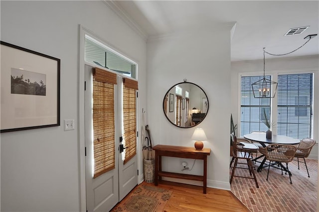 18123 Cusachs Dr, Covington, LA 70433 - entrance foyer featuring baseboards, crown molding, a chandelier, and light wood finished floors
