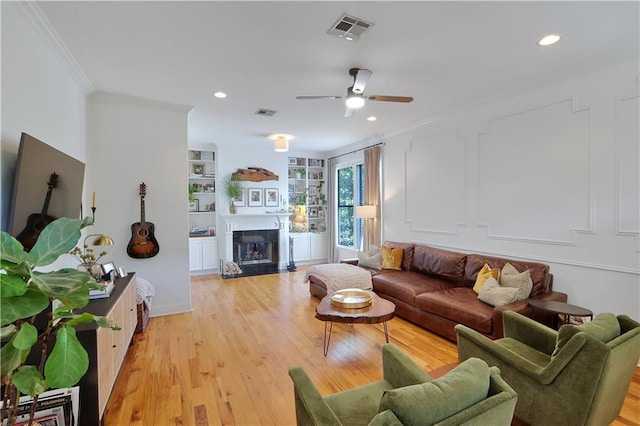18123 Cusachs Dr, Covington, LA 70433 - living room with crown molding, a ceiling fan, light wood finished floors, a fireplace, and recessed lighting