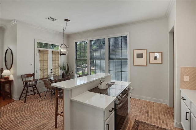 18123 Cusachs Dr, Covington, LA 70433 - kitchen with brick flooring, baseboards, light countertops, range with electric stovetop, and ornamental molding
